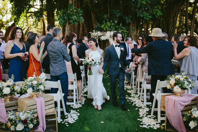 Silhouette of two men kissing with the blue sky and ocean behind them at their Micro Wedding