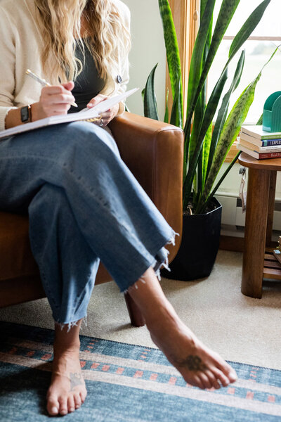 Amy Fink sitting in her office writing in a notebook