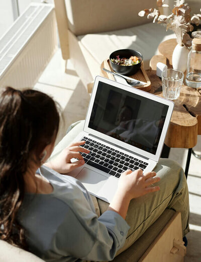 A woman who is sitting down and looking at her computer