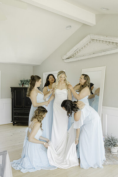 bride standing in her wedding dress looking over her left shoulder out the window