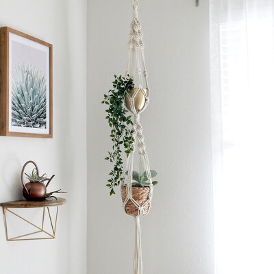 This premium macrame plant hanger is handmade with 100% cotton rope, making it strong and durable. Easily hang two of your favorite house plants in this double macrame plant hanger. Attach to a ceiling hook and hang near a window to best display this planter.
