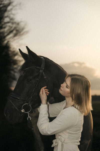Portret van ruiter en paard, vastgelegd tijdens een verhalende fotoshoot in een rustige omgeving.
