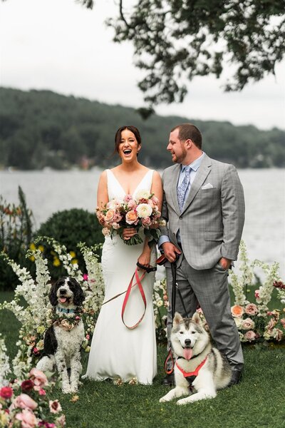 Nicole and John laughing on their wedding day with their dog
