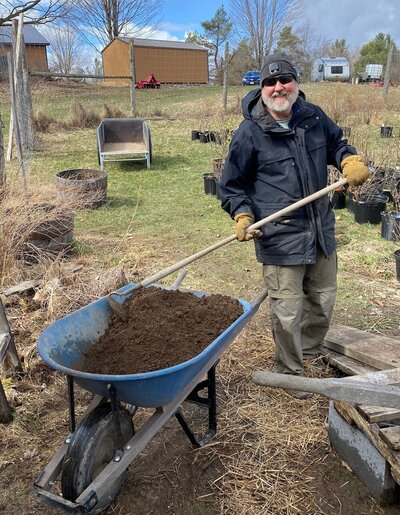 Will standing on farm in the winter next to wheel barrow full of homemade potting soil mix 