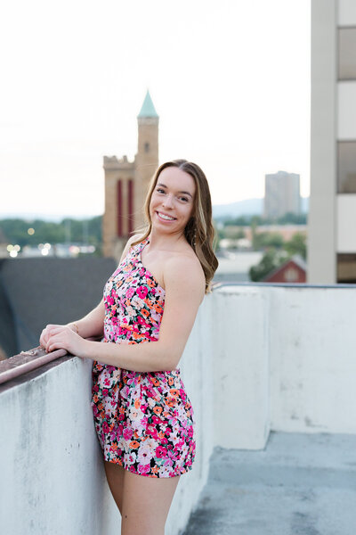 senior girl posing against a wall on rooftop garage in Chattanooga