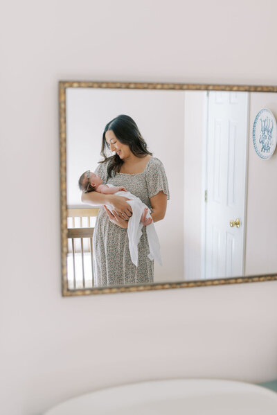  Richmond Newborn Photographer | Closeup photo of a mother’s hand holding her newborn son’s fingers on a white blanket 