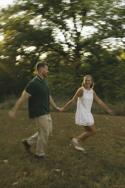 groom holding bride in field during golden hour
