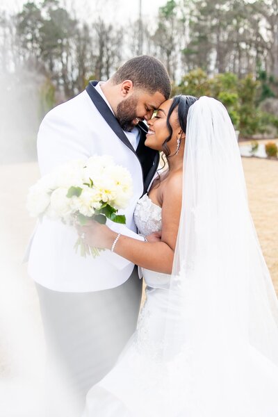 Bride and groom embracing each other, smiling