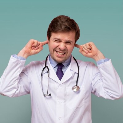 Doctor in lab coat plugging ears with fingers