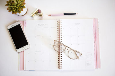 Planner open on a table with glasses on top
