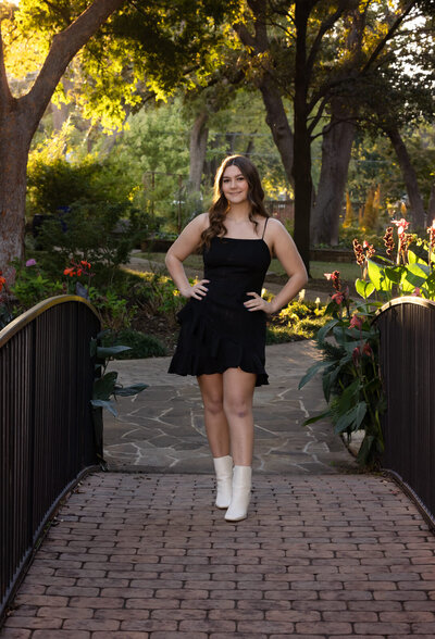 girl-in-black-dress-standing-on-bridge-with-white-boots