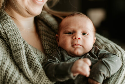 Cute baby boy looking at the camera during his first photo shoot with family in Winnipeg