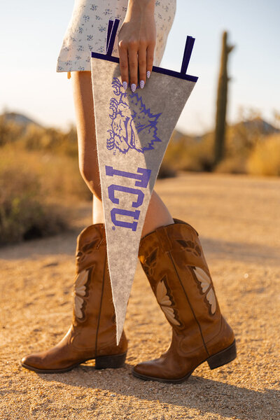 girl holds TCU flag for graduation photos in arizona desert