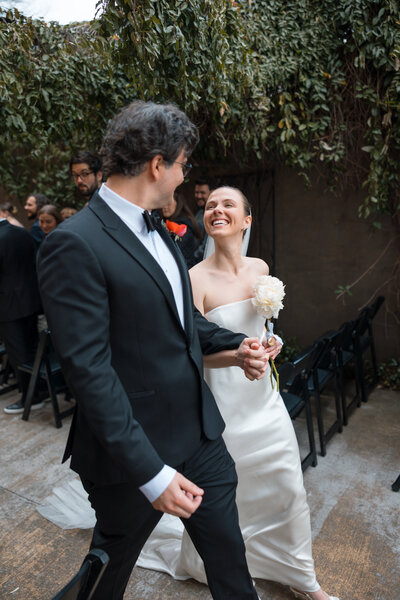 Bride and groom hold hands as the bride twirls