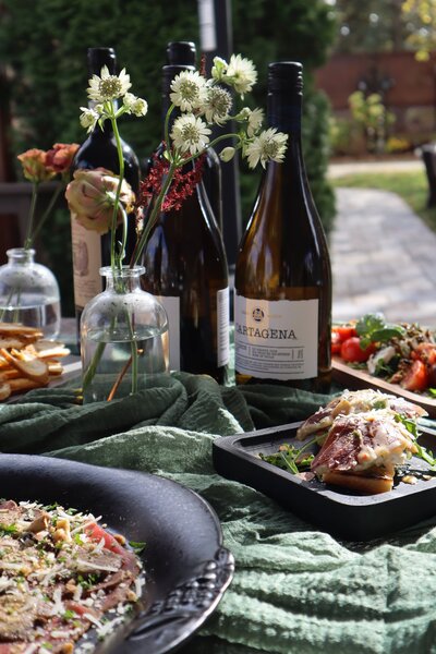 Wine bottles, flowers, and plated dishes set on a styled dining table for a private event at Ashlar Ottawa.