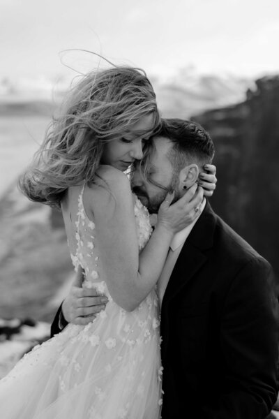 Creatieve en sfeervolle elopementfotografie door een trouwfotograaf gespecialiseerd in bruiloften en elopements. De bruidsfoto’s zijn gemaakt op een klif in IJsland. 