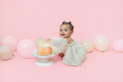 ! year old eating cake druing milestone photoshoot