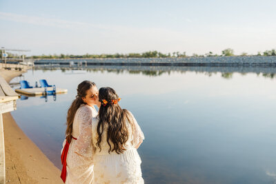 Omaha and Lincoln queer wedding photography of two brides by a lake taken by Claire Katan Creative.