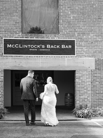 bride and groom in front of mcclintock's bar in frederick MD, taken by wedding photographers