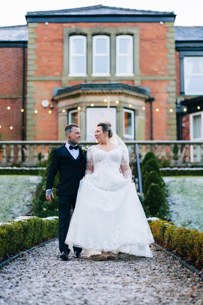 Couple walkiong through gardens at Ashfield House taken by Anthony Horseman Wedding photographer adn videographer