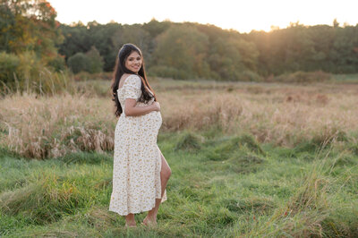 pregnant woman smiling in  a field