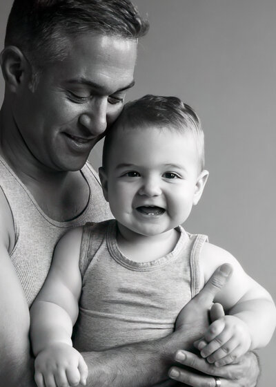 black and white studio portrait of father and son captured by Allison Amores Photography McKinney Family Photographer