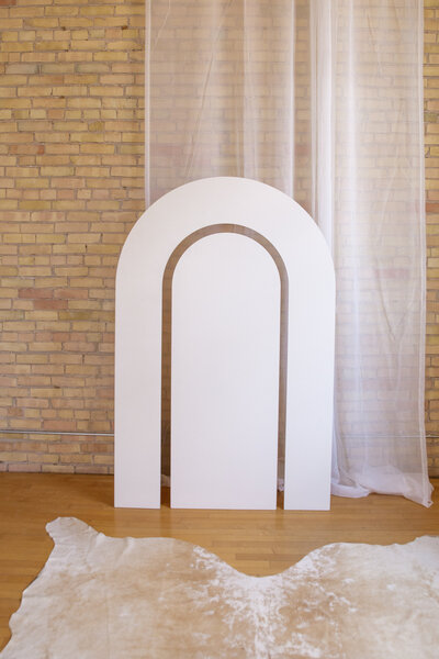 A six foot white arch with a rainbow cutout.