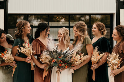 bridesmaids standing smiling at each other