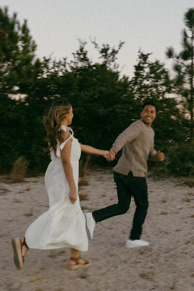 couple running on beach at elopement