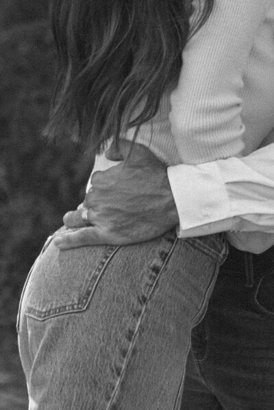 A black and white photo of a couple leaning in close to each other conveying a storytelling perspective.