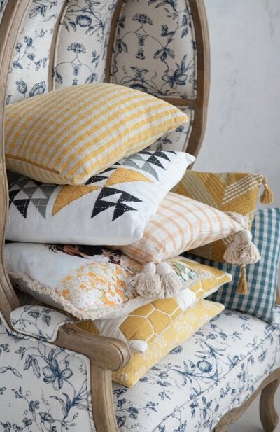 Florentine hooded porters chair stacked with yellow designer pillows