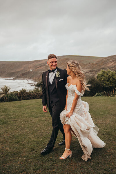 elegant and stylish couple walk by the ocean