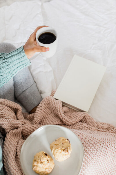 A close up of a woman in bed with notebook