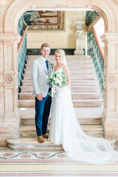 couple of bride and groom stand on stair at chateau de varenne