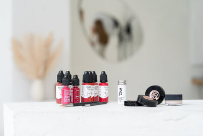 lahvičky s barvou na permanentní make up rtů na bílém stole