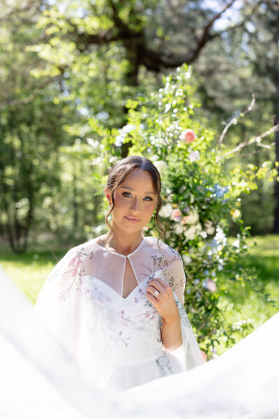 Bride outside by flower arrangement outside — Madison Abernathy Photo