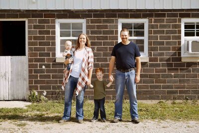 Family of 4 smiling on farm