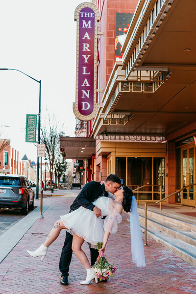 Groom dipping bride for a kiss outside a historic downtown Hagerstown venue during their urban elopement.
