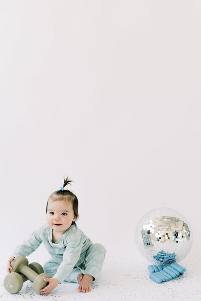 Baby holding dumbbells