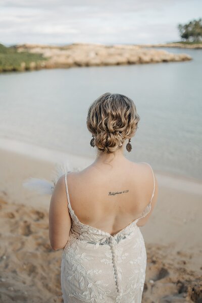 Detail photo of bride's curly hair updo standing at a lake