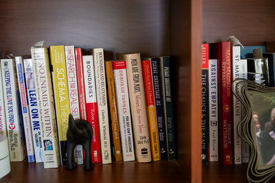 Bookshelf featuring personal growth books, representing Audrie Meyer's approach to resource building in spiritual coaching.