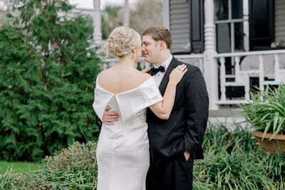 bride and groom embrace by lake for Mississippi wedding photographer