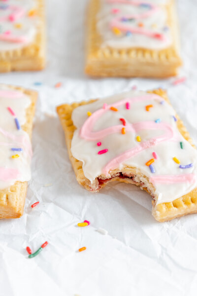 a homemade pop tart decorated with pink and white frosting and sprinkles