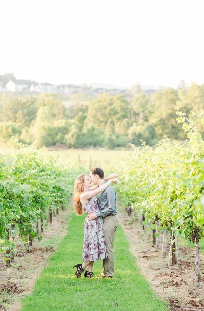 couple rubbing noses together in a stunning vineyard during their Nashville summer engagement session