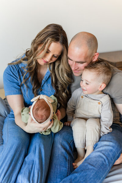 newborn baby laying on a bed asleep posed for newborn photos in st goerge utah