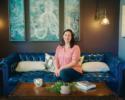 Kat Jackson sitting on a vibrant blue couch as a representation of brand imagery.