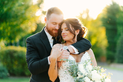 bride and groom embracing during sunset