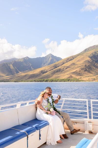Wedding couple cuddling on a boat during their Maui Wedding