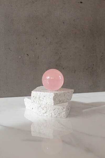 A high quality pink rose quartz crystal sphere - our Unconditional Love ball, on a quartz slab.