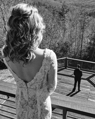 Bride looking down over a balcony at her soon to be husband